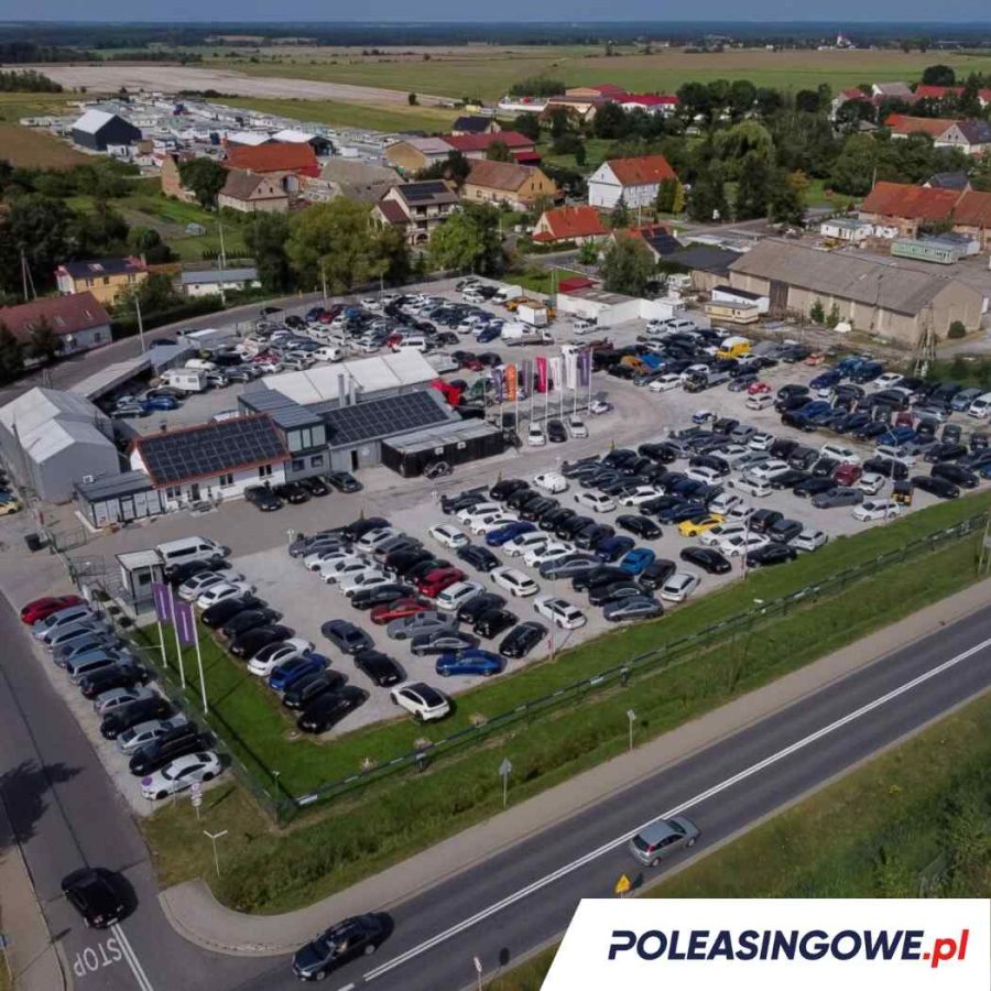 Lotnicze ujęcie dużego placu z samochodami poleasingowymi na sprzedaż. Bogata oferta pojazdów używanych dla firm i osób prywatnych.