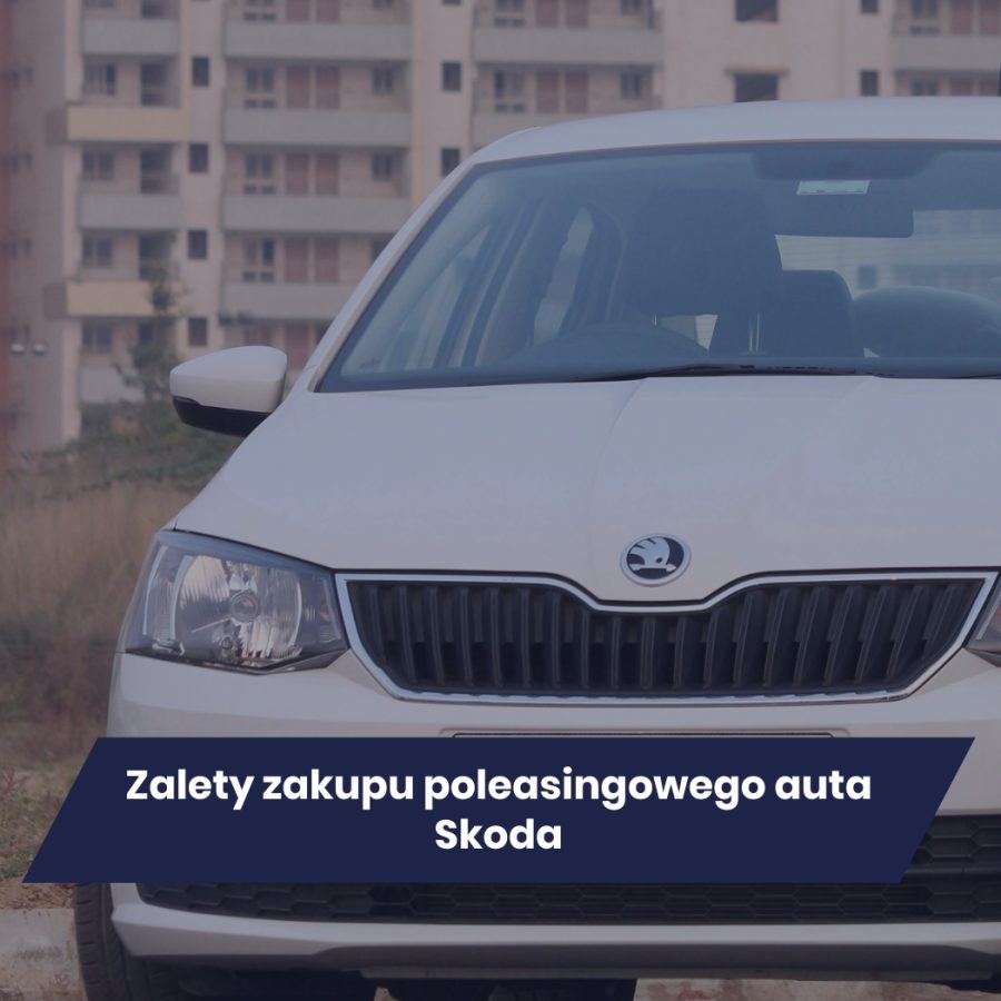 Biała Skoda na tle budynków, przód pojazdu z widocznym grillem i reflektorami.