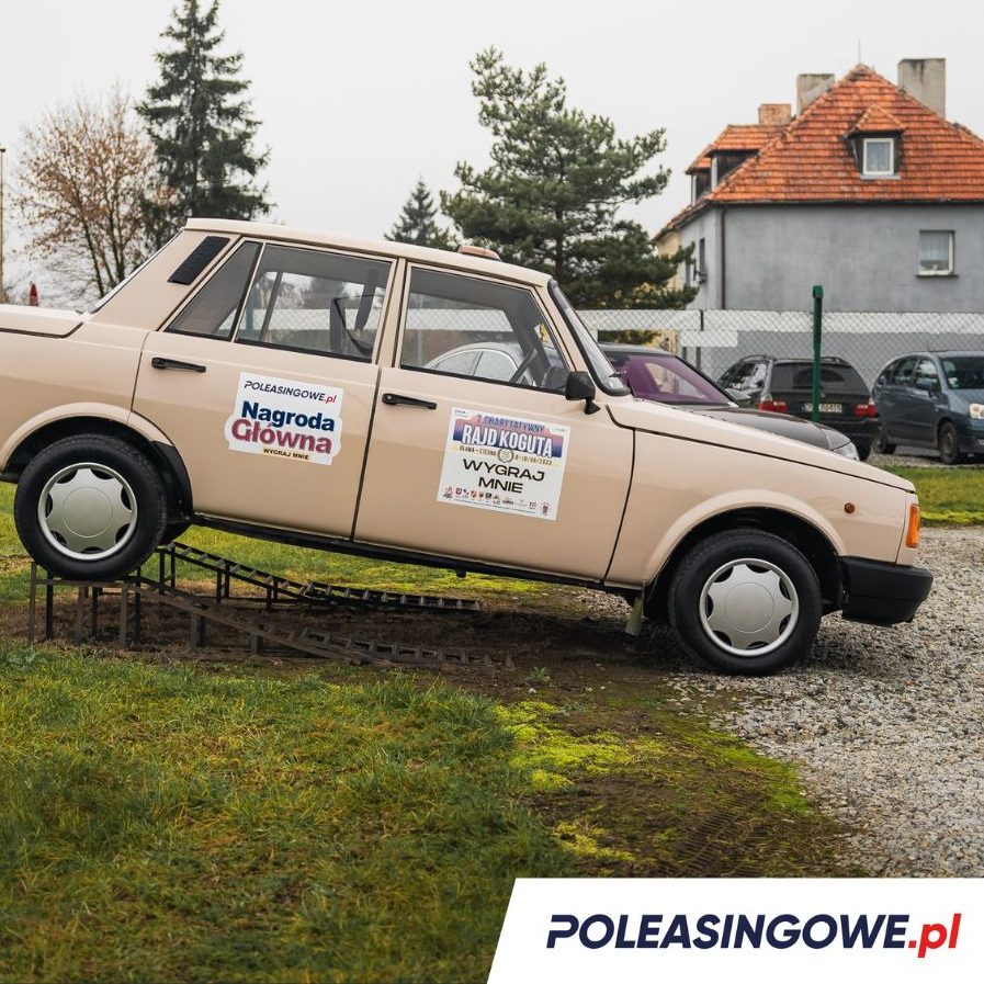 Klasyczny Wartburg 1990 na ekspozycji, udekorowany napisami „Nagroda Główna” i „Rajd Koguta”. Logo Poleasingowe.pl na drzwiach pojazdu.